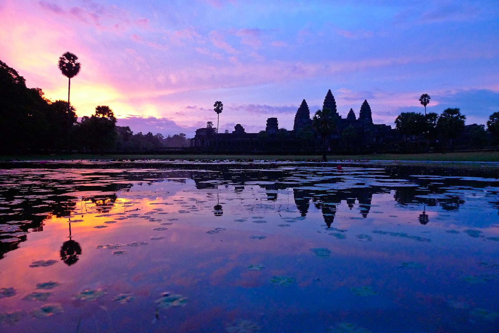 Torres de Angkor Wat refletidas na água ao amanhecer, em Siem Reap, Camboja