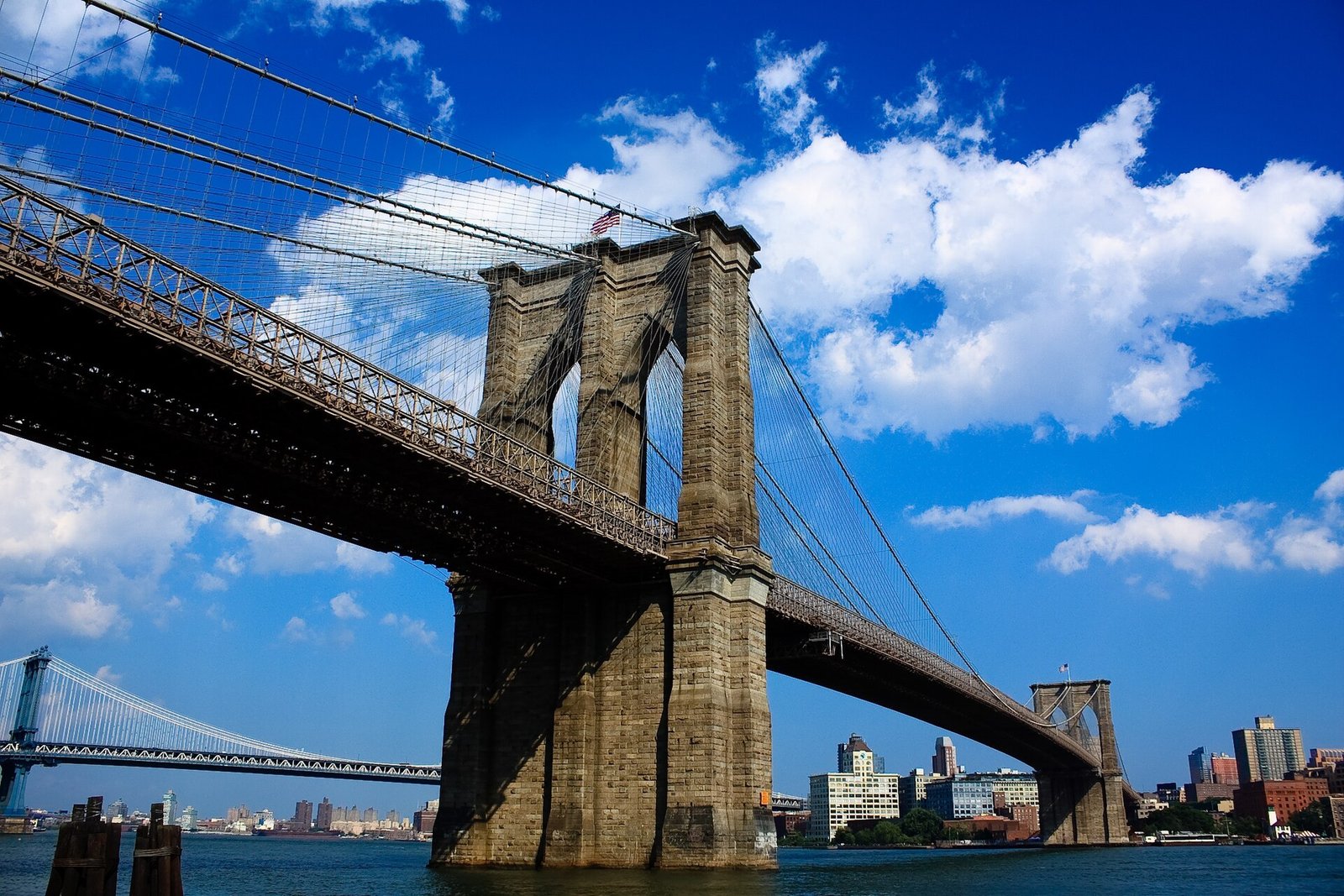 Vista de baixo para cima da torre de pedra da Brooklyn Bridge, Nova York