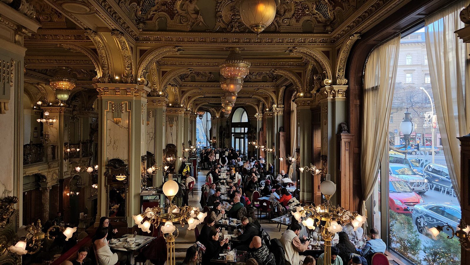 Salão dourado do Café New York, em Budapeste, com colunas e afrescos no teto