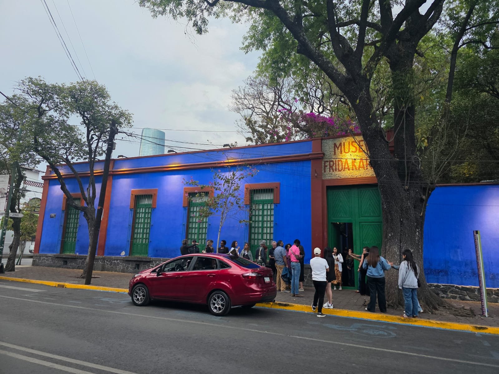 Fachada azul do Museu Frida Kahlo (Casa Azul) em Coyoacán, com visitantes na entrada