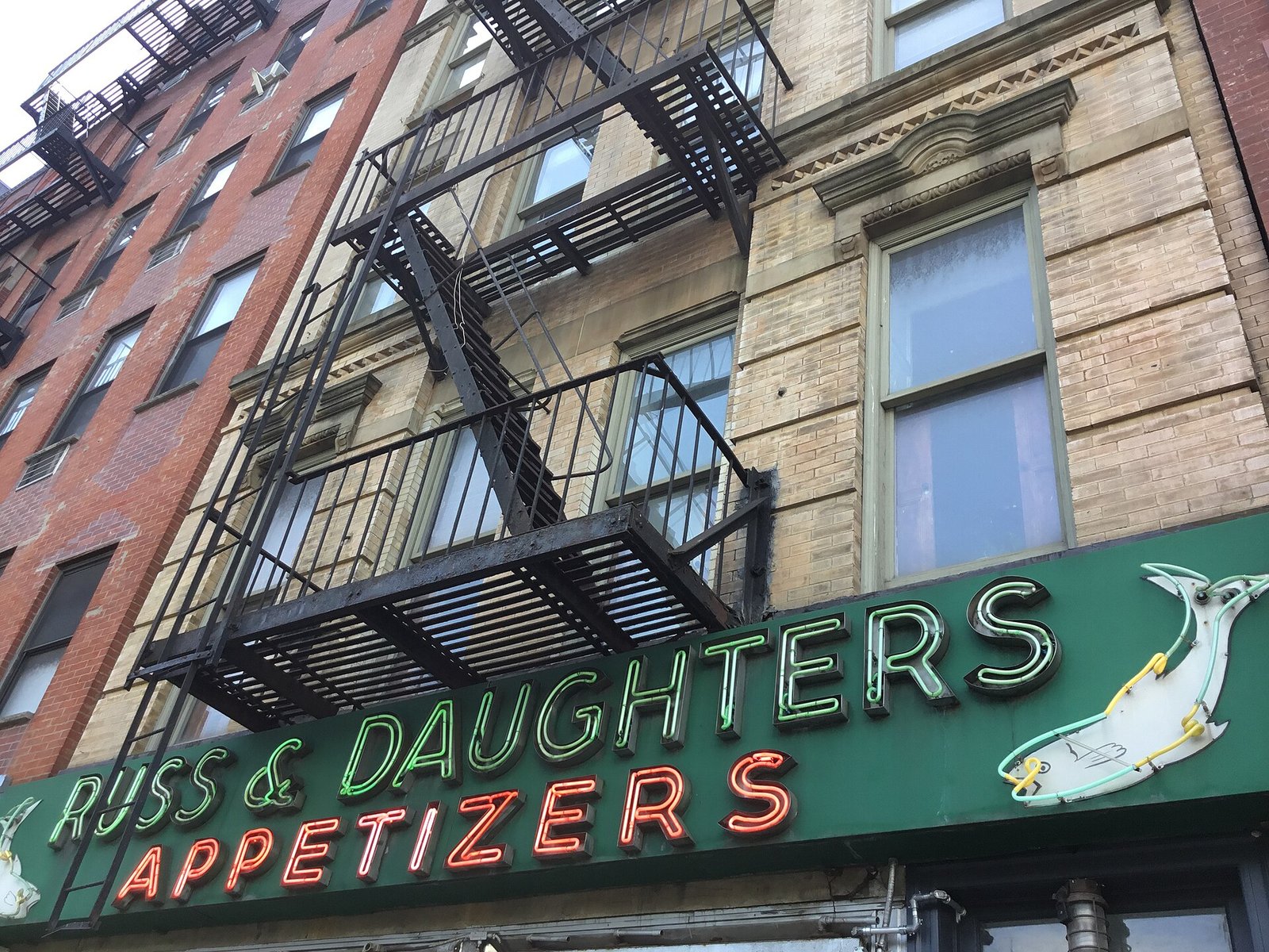Fachada da Russ & Daughters com letreiro de neon no Lower East Side, Nova York