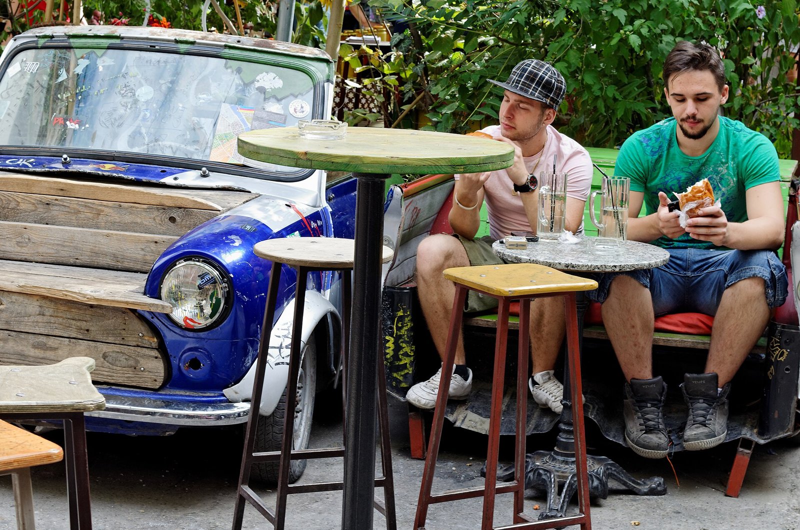 Pátio interno do Szimpla Kert, em Budapeste, com paredes descascadas e móveis desencontrados
